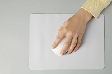 Woman using modern wireless computer mouse on grey background, top view