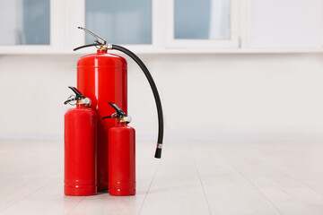 Fire extinguishers on floor indoors, space for text