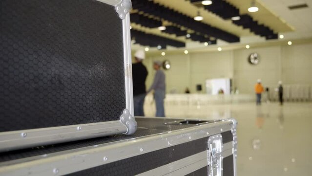 a task force of out-of-focus engineers at work setting up a stage for a conference