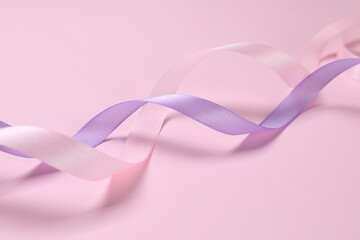 Beautiful ribbons in different colors on pink background