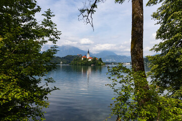 Obraz premium Panoramic view from Lake Bled, beauty heritage in Slovenia. Island with church and castle in the background create a dream setting. View from Ojstrica and Mala Osojnica with the heart-shaped bench.