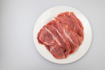 Raw turkey fillet, Poultry meat on white plate. Top View.