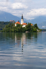 Obraz premium Panoramic view from Lake Bled, beauty heritage in Slovenia. Island with church and castle in the background create a dream setting. View from Ojstrica and Mala Osojnica with the heart-shaped bench.