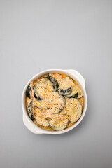 close-up baked zucchini baked with sauce in bowl