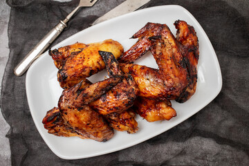 Baked chicken wings with sweet chili sauce in a plate.