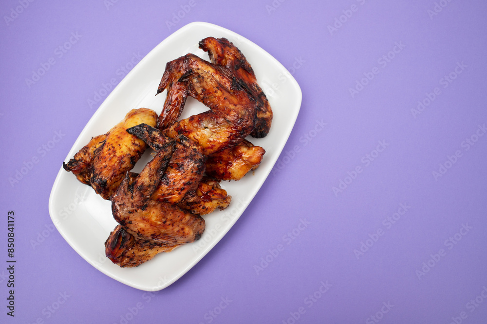 Sticker baked chicken wings with sweet chili sauce in a plate.