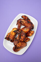 Baked chicken wings with sweet chili sauce in a plate.