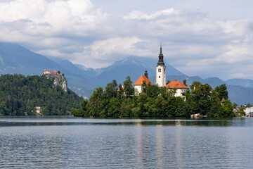 Panoramic view from Lake Bled, beauty heritage in Slovenia. Island with church and castle in the background create a dream setting. View from Ojstrica and Mala Osojnica with the heart-shaped bench.