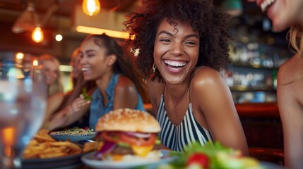 A woman is smiling and eating a hamburger in front of a group of people