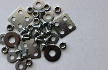 Bunch of assorted washers, spacers, nuts and bolts on the scratched surface of a workbench. Stock Photo For Metal Hardware Illustration
