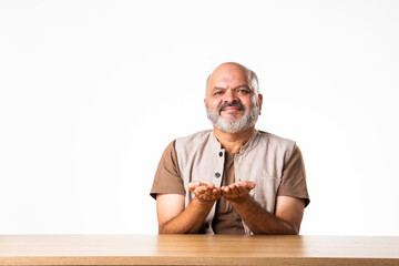 Expressive Indian asian old retired senior man sitting at table