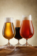 Three glasses of different kinds beer on a wooden countertop. Craft beer. Shallow depth of field. 