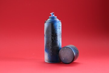 One can of bright spray paint with cap on red background