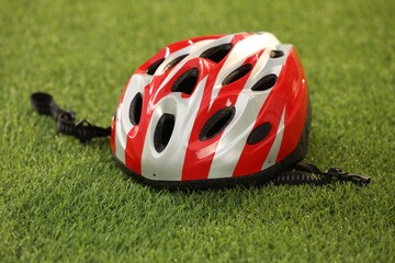 One colorful protective helmet on green grass