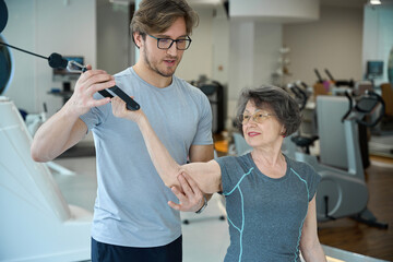 Female pensioner performs exercises to strengthen muscles