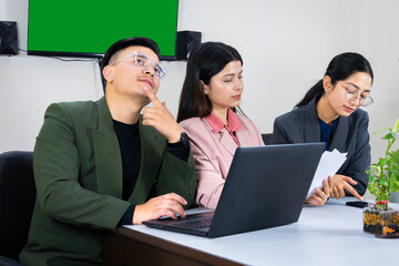an office team of business man and woman in front of a green screen in a meeting table discussing