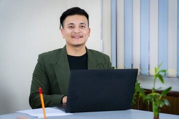 A young business manager entrepreneur working in an office room with a laptop 