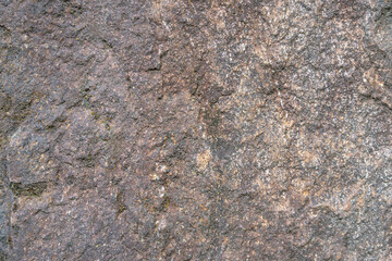 Dark, rough stone background with light-colored veins of various colors. High quality photo