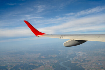 Airplane wing in flight. A view of the country through an airplane window.