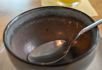 Empty soup bowl and spoon. Eaten soup.