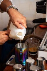 Barista Steaming Milk With a Coffee Machine Pitcher in a Modern Cafe