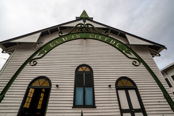 Old wooden church with an entrance arch with the title: God is Liefde (God is Love) in the old...