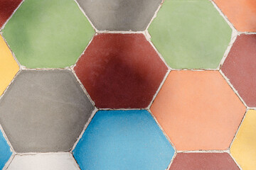 A colorful mosaic tile pattern with a variety of colors. The tiles are arranged in a hexagonal...