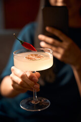 Woman making the photo of delightful signature cocktail