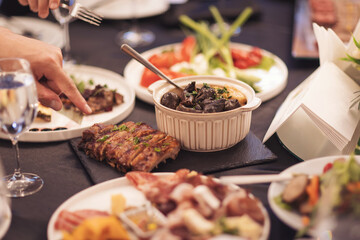 Dinner party food concept. Dinner table with grilled sausage, tortilla wraps, beer drink and different dishes on wooden table, rustic style. Meat dishes on a wooden table. 