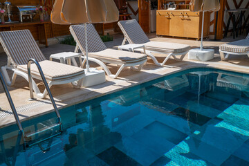 Empty swimming pool in the hotel in summer. Swimming pool with umbrella chairs in a beautiful swimming pool in a tropical resort.