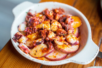 Grilled octopus with chorizo and white bean. Chorizo is seasoned, coarsely ground, pork sausage, a rural village meat in Spain. Octopus is simmered in clay pot, stir fried with tomato sauce