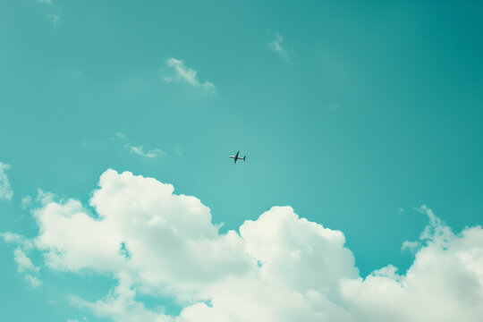 photo of blue sky with clouds and airplane flying in the distance, in the style of unsplash photography.Minimal creative travel concept.