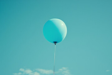 Obraz premium Minimalist aesthetic of a cyan balloon floating against a clear, blue sky,