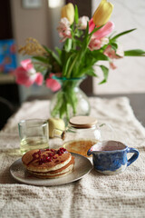 Simple pancake breakfast with jam and apple, tea served on a kitchen table. Simple life concept High quality photo