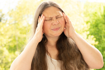 diseased mature woman experiences severe headache, holding head, Hot flashes during menopause,...