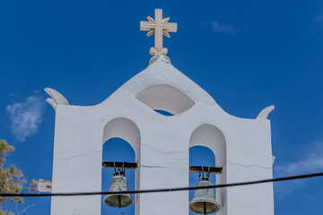 Beautiful whitewashed orthodox church in Ios Greece and a blue sky in the background