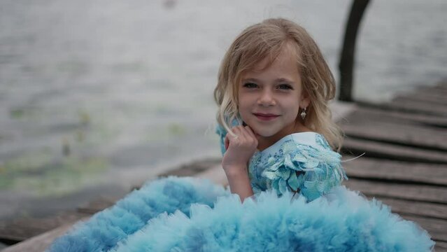 Cute little child in princess dress looking at camera. Happy childhood concept.
