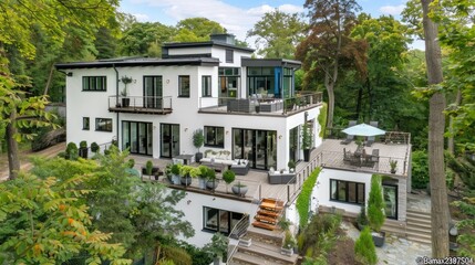 Fototapeta premium a modern country house with a wooden terrace, green lawn, white walls, and a gray roof, showcasing contemporary architecture.