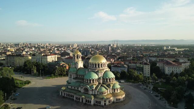 Aerial drone shot of the Cathedral St. Alexander Nevsky in Sofia Bulgaria. Bulgarian orthodox church during sunrise surrounded by green trees. Orthodox cathedral. Flying from drone.