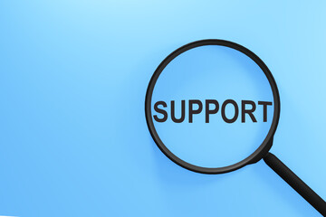 A magnifying glass focused on the word support underneath it, depicting the concept of seeking assistance or help.