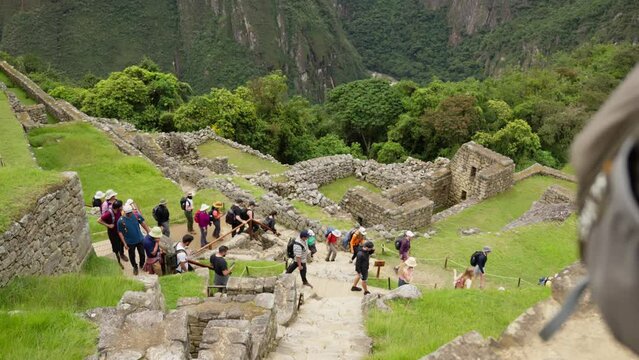 Tourists Exploring Machu Picchu Ruins. Visitors walking through and enjoying the historic site of Machu Picchu
