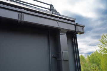 Metal gutter drainage system on the roof © Sergey