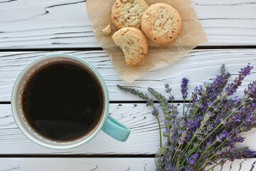 Overhead view of black coffee on a distressed white wood table with fresh lavender and cookies © MargJohnsonVA