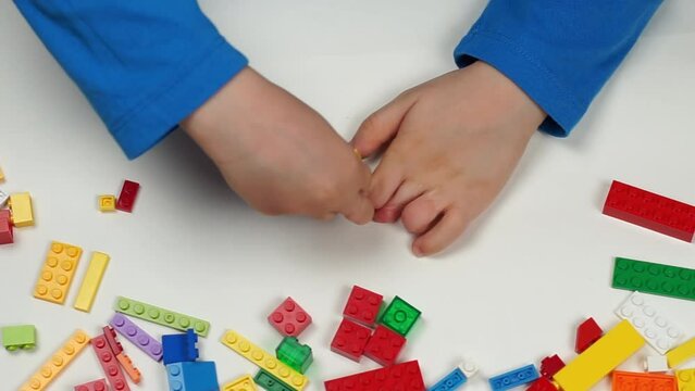 Child with disability building colorful blocks against white background