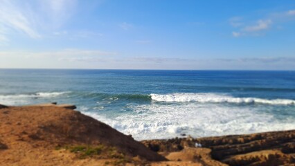Powerful ocean waves crashing on the shore on a sunny day