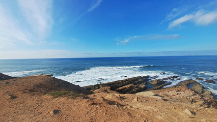 Rocky coastline meeting the ocean on a sunny day