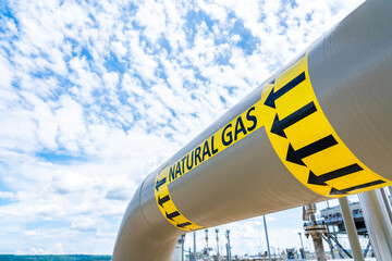 Natural gas pipeline with high pressure and direction sign at compressor station. Concept of energy...