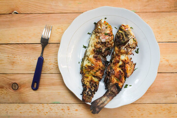 grilled fish in a plate on a wooden table