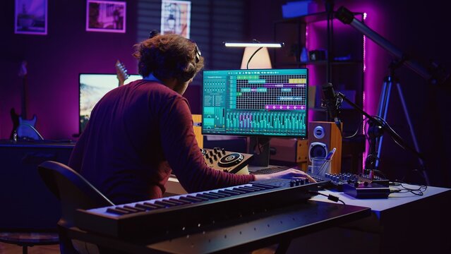 Music engineer using usb stick to edit and add sound effects on audio recording, adjusted volume levels. Artist doing mixing and mastering technique on soundboard, plays piano. Camera B.