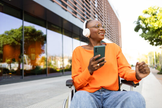 Black woman in wheelchair enjoying music outdoors